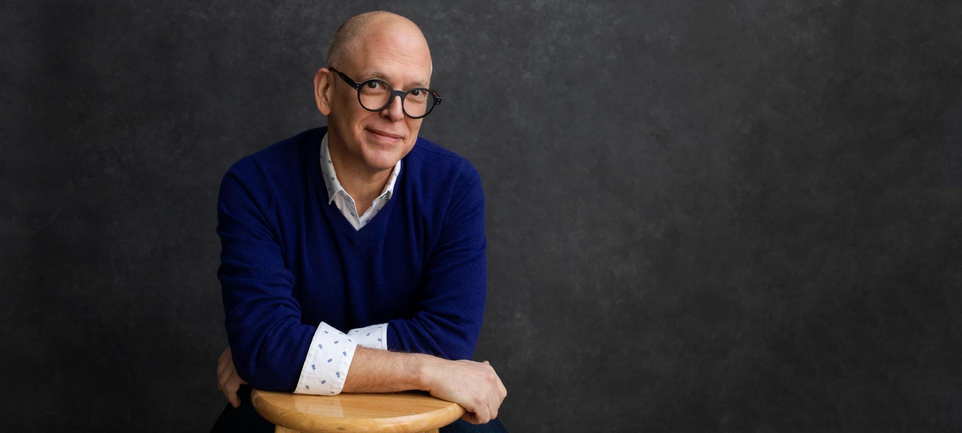 Jeff obergefell poses in front of a dark grey backdrop.